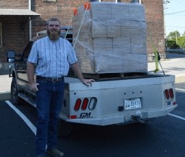 Charlie Crume is shown with donated Castle and Key hand sanitizer.